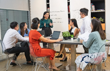 A group of young people in office attire discussing