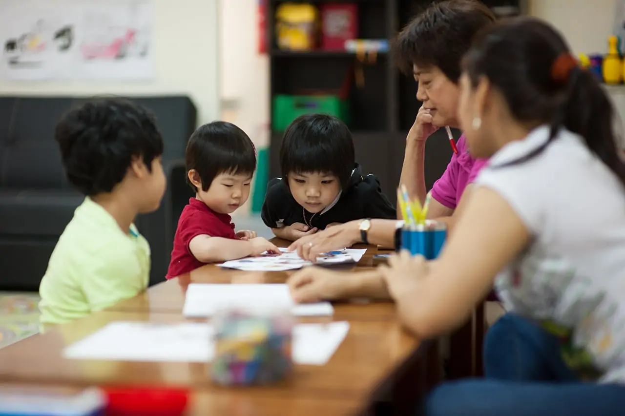 a group of people sitting at a table with a group of children