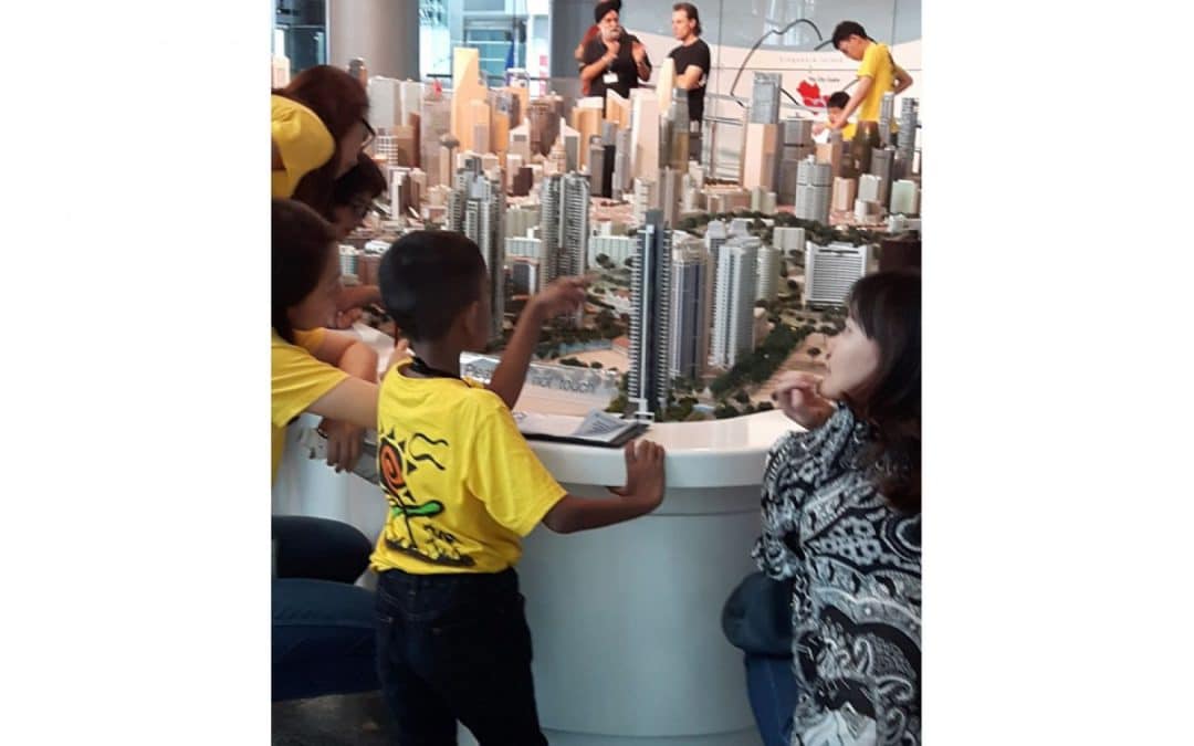 a group of people looking at a model of a city