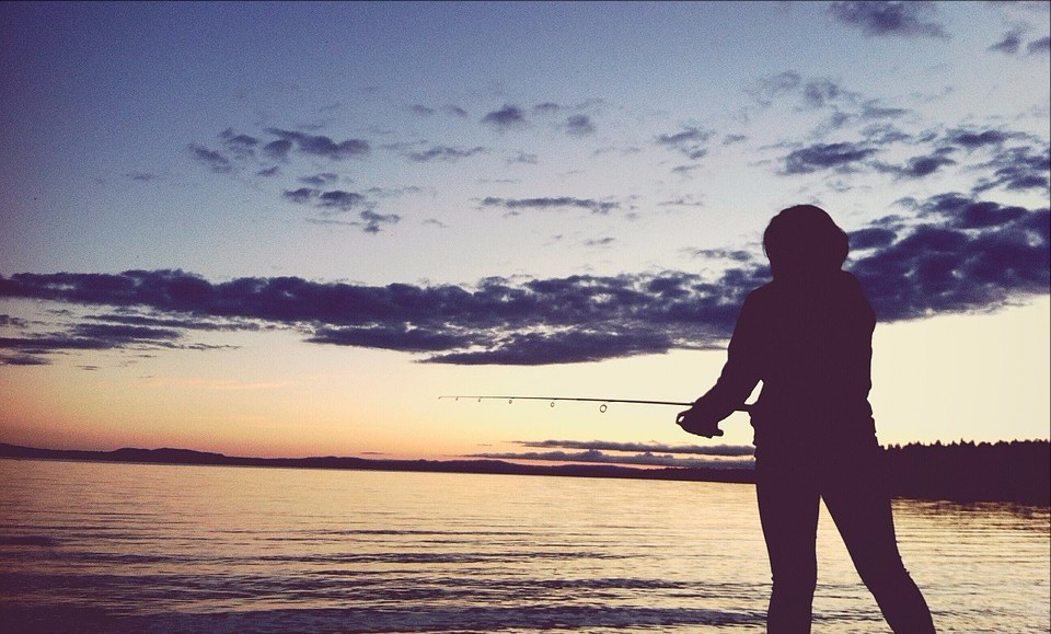 Black silhouette of a woman fishing