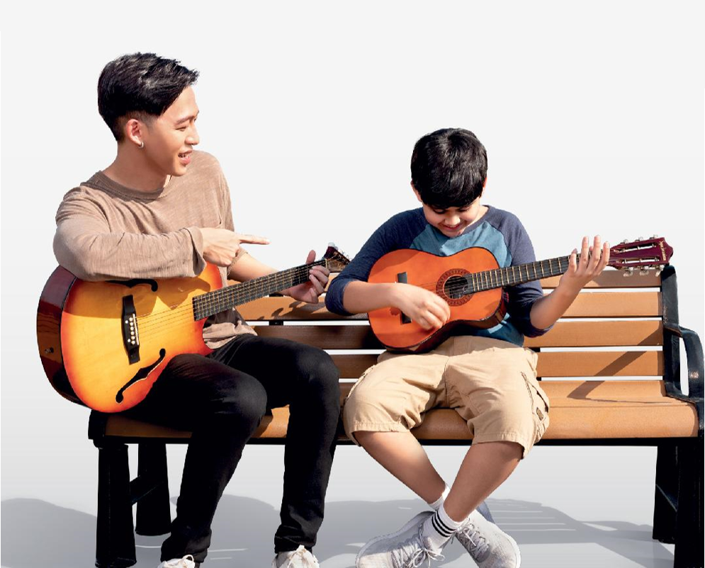 a man teaching a kid guitar