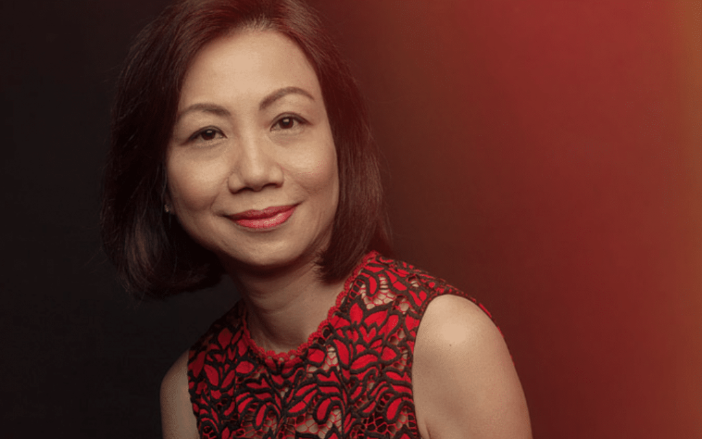 Asian woman (Ms Loh) in red dress posing for camera.