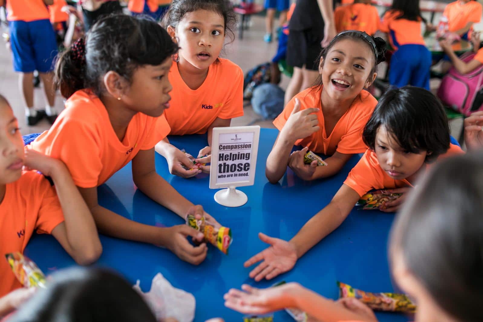 a group of kids in orange tees